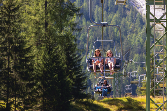 Mit der Sesselbahn auf die Alp Darlux (Foto: © Nico Schaerer) Eine Familie fährt mit der Sesselbahn auf die Alp Darlux im Parc Ela