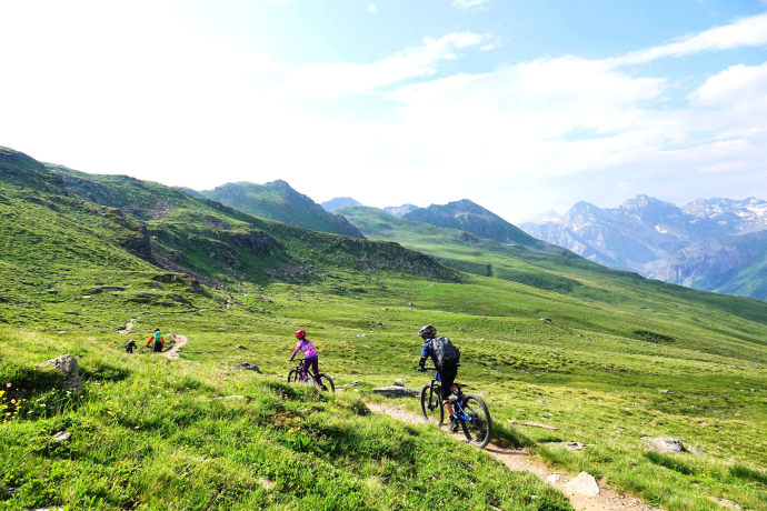 Trailvergnügen mit Panoramablick Kinder fahren auf einem Panorama-Trail mit Blick auf die Berge
