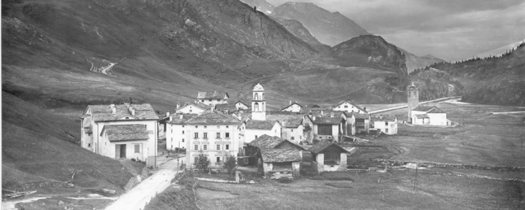 Die Julierstrasse durch Bivio im Zeitraum 1890-1936. Damals war der Belag noch nicht befestigt, Postkutschen konnten die Passstrasse jedoch befahren.