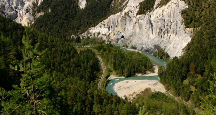 Der Rhein schlängelt sich durch die Rheinschlucht. Steile Felswände und Wald rundherum.