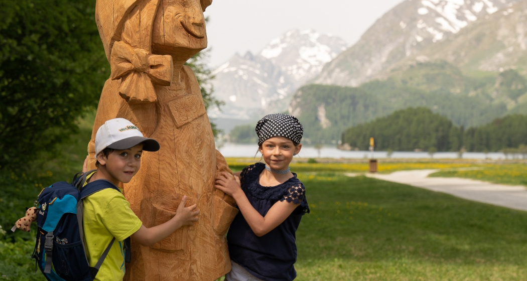 Holzfigur Gianna mit Kindern in der Silsersee Ebene Holzfigur Gianna mit Kindern in der Silsersee Ebene