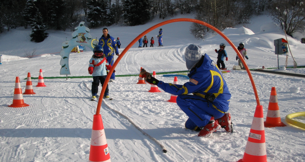 Das Foto zeigt einen Skilehrer der ein junges Mädchen das Skifahren beibringt Das Foto zeigt einen Skilehrer der ein junges Mädchen das Skifahren beibringt