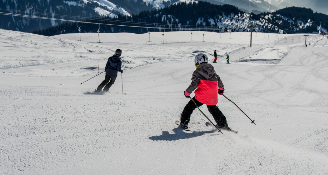Das Foto zeigt ein Mann und ein junges Mädchen, welches die Piste neben dem Skilift Miret abfahren Das Foto zeigt ein Mann und ein junges Mädchen, welches die Piste neben dem Skilift Miret abfahren