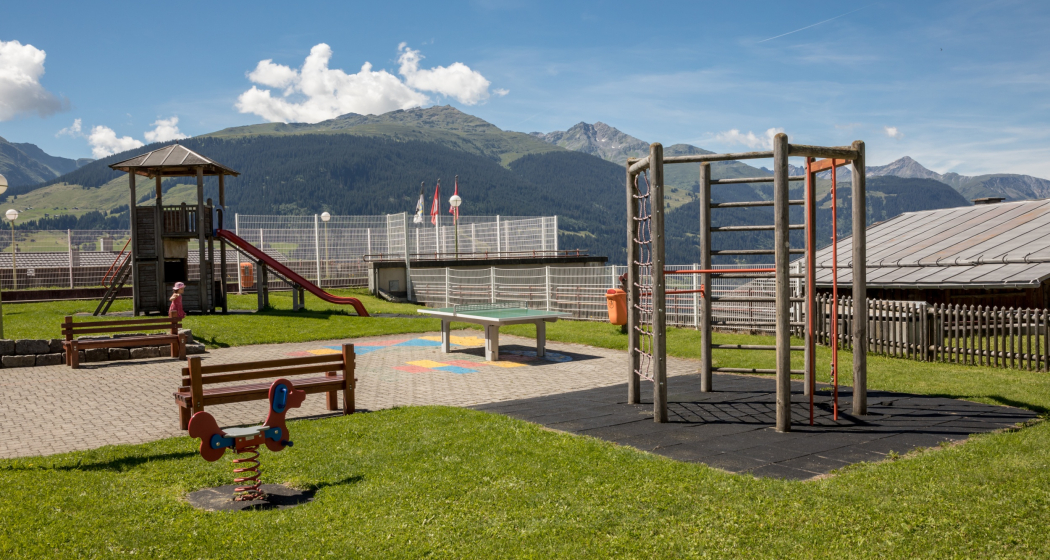 Das Foto zeigt den Spielplatz beim Schulhaus in Brigels mit einer Rutsche und Klettermöglichkeit Das Foto zeigt den Spielplatz beim Schulhaus in Brigels mit einer Rutsche und Klettermöglichkeit