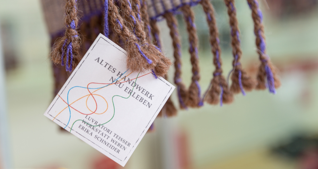 Das Foto zeigt das Logo der Werkstatt Weben in Brigels