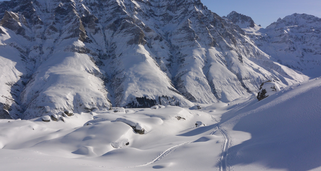 Vorbei an den tief eingeschneiten Felsbrocken. Sicht zum Gelbhorn und Bruschghorn.