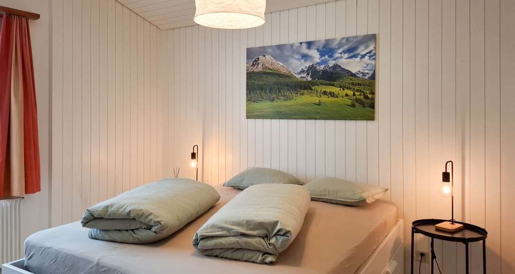 Grosses Schlafzimmer mit Blick in den Garten. Ausgestattet mit einem Queen-Size Bett (160cm)