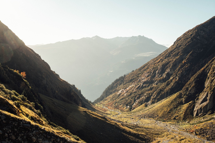 Ein Tal von der Sonne in warmes Licht gebettet.