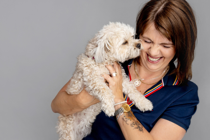 Nahaufnahme von Frau Killias mit einem Hund im Arm.