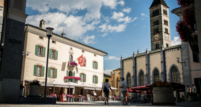 Reges Leben auf der Plazza da Cumün – der Treffpunkt im Herzen von Poschiavo (Foto: © Marco Hartmann) Menschen geniessen das geschäftige Treiben auf der zentralen Plazza da Cumün in Poschiavo