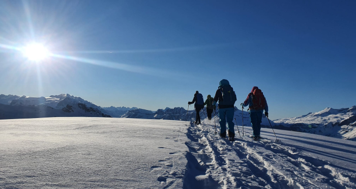 Mit Anita Gschwind unterwegs auf einer Schneeschuhtour Gruppe auf Schneeschuhtour bei strahlendem Sonnenschein in den Schweizer Alpen