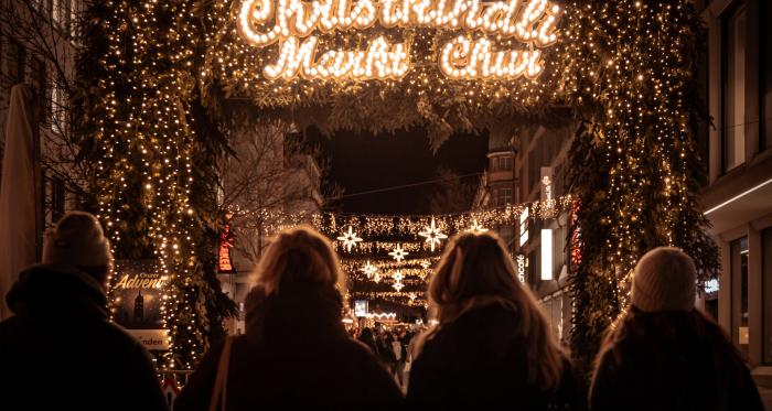 Beleuchteter Eingang zum Christkindlimarkt Chur am Abend in der Innenstadt