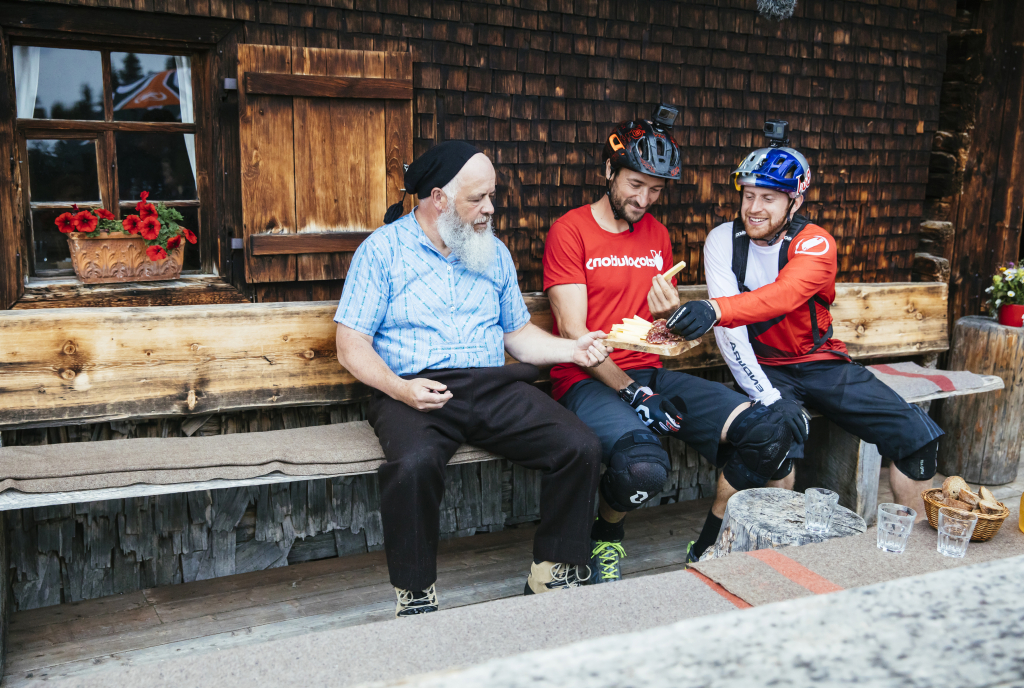 Pause machen bei der Alphütte Fops: Danny MacAskill und Claudio Caluori stärken sich mit einem Bündner-Plättli (Bild: Martin Bissig)