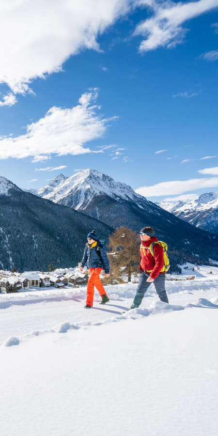 Zwei Winterwanderer geniessen die Aussicht auf der Via Engiadina