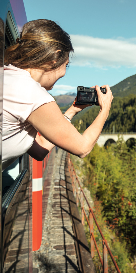 Eine Passagierin der Rhätischen Bahn fotografiert das Landwasserviadukt