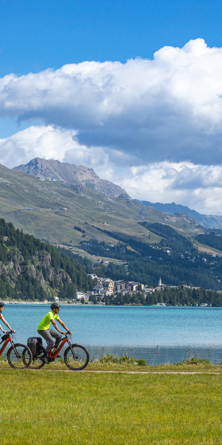 Zwei Fahrradfahrende am Ufer des Silvaplanersees