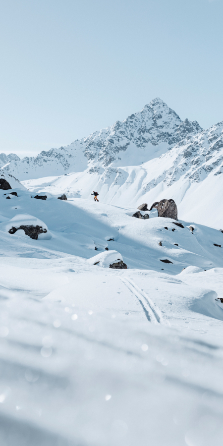Ein Skitourengänger in der winterlichen Berglandschaft von Davos Klosters