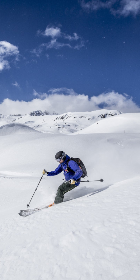 Ein Skifahrer fährt eine Piste im Skigebiet Minschuns in der Val Müstair hinunter