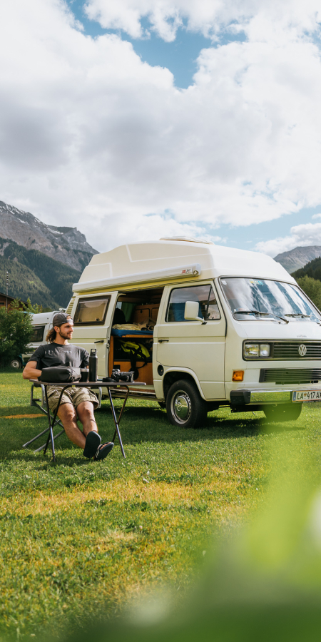 Camping Muglin in Müstair mit Camper und VW-Bus vor Bergkulisse