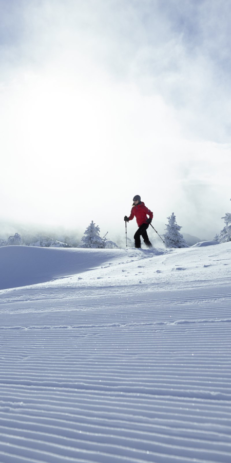 Alleinreisende Person beim Schneeschuhwandern durch verschneite Winterlandschaft in Graubünden