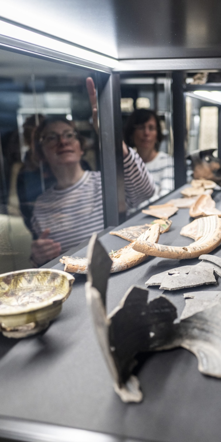 Salle d’exposition du musée du monastère de Saint-Jean à Müstair avec des objets archéologiques présentés dans des vitrines