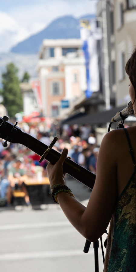 Eine Frau ist auf der Bühne und hat eine Gitarre in der Hand und singt.