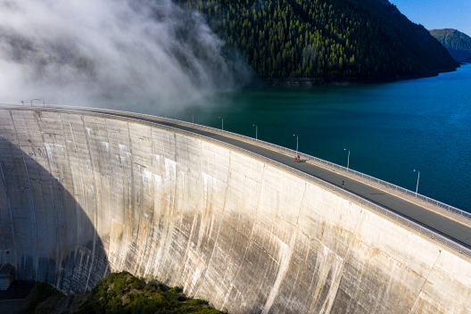 Die über 100 Meter hohe Staumauer am Lago di Livigno (Foto: © Graubünden Ferien / Andreas Meyer) Nathalia Schneitter und Florian Vogel fahren über die Staumauer am Lago di Livigno