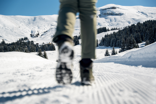Person auf dem beschneiten Weg der Via Mundaun