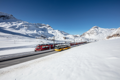 Un autopostale e un treno della Ferrovia Retica sul Passo del Bernina