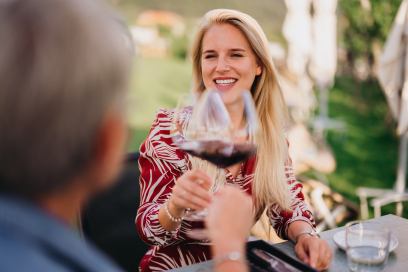 Zwei Frauen stossen mit Weingläsern in den Rebbergen von Jenins an