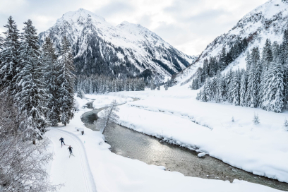Winterzauber in Klosters – Langlaufen auf der Garfiuner Roller Coaster Loipe entlang der Landquart (Foto: © Martin Bissig) Ein Paar gleitet auf der Garfiuner Roller Coaster Loipe in Klosters, begleitet vom leisen Plätschern der Landquart und einer malerischen Winterkulisse