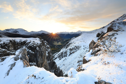 Verschneite Berglandschaft im Val Müstair mit Blick ins Tal bei Sonnenaufgang