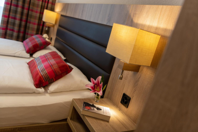 Chambre avec lit double dans un appartement de vacances premium sans obstacles au Pradas Resort Brigels