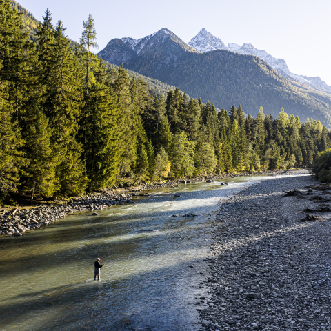 Ein Fliegenfischer steht im Inn im Unterengadin