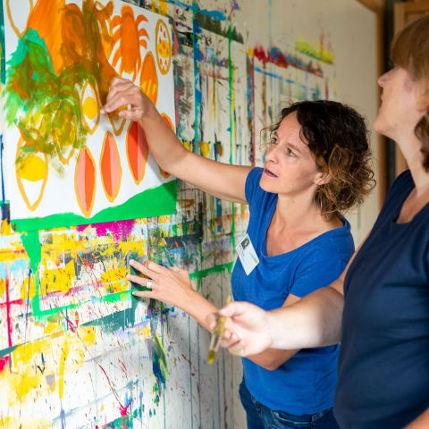 Kreative Sprache im beruflichen Alltag (Foto: © Psychiatrische Dienste Graubünden) Zwei Frauen analysieren eine bemalte Wand