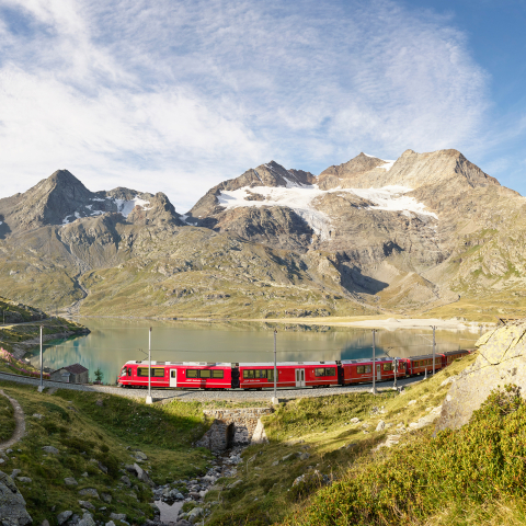 Ein Zug der Rhätischen Bahn fährt am Lago Bianco entlang