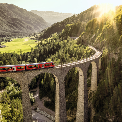 Un train des Chemins de fer rhétiques traverse le viaduc de Landwasser dans le paysage Albula/Bernina