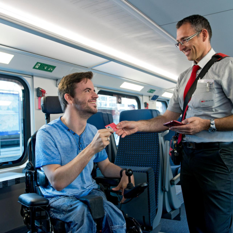 Ein Kundenbegleiter der SBB kontrolliert das Billett eines Reisenden mit eingeschränkter Mobilität