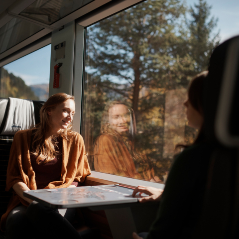 Meisterleistungen der Ingenieurskunst: die Fahrt mit der Rhätischen Bahn ist ein aussichtsreiches Erlebnis (Foto: © Samuel Trümpy) Eine Frau blickt aus dem Fenster eines Zuges der Rhätischen Bahn