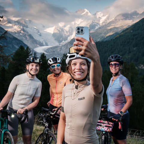 Frauen auf Mountainbikes, eine macht ein Selfie mit ihren Freundinnen vor dem Morteratschgletscher