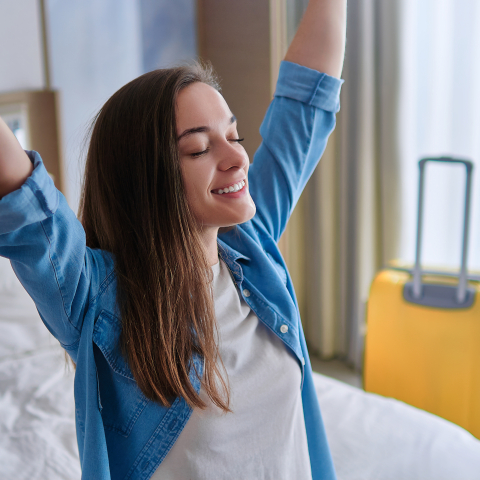 Junge alleinreisende Frau im Hotelzimmer Alleinreisende