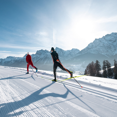 Langlaufen im Unterengadin mit freiem Blick auf die winterliche Landschaft (Foto: © Filip Zuan) Zwei Langläufer auf frisch präparierter Panoramaloipe im Unterengadin
