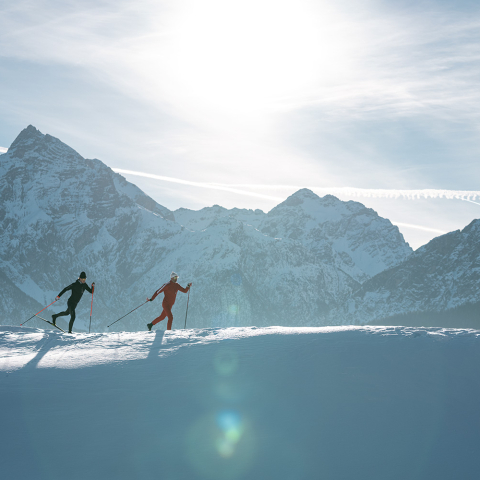 Zwei Langlaufende im Unterengadin im Hintergrund das Bergpanorama (©Filip Zuan)