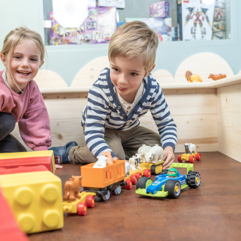 Zwei Kinder spielen mit LEGO Duplo und Spielzeugautos im Kids Inn by LEGO im Valbella Resort Lenzerheide