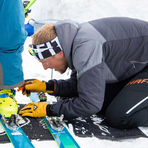 Ein Bergführer stellt die Skitourenschuhe eines Kursteilnehmers ein (Foto: © Martin Hoch)