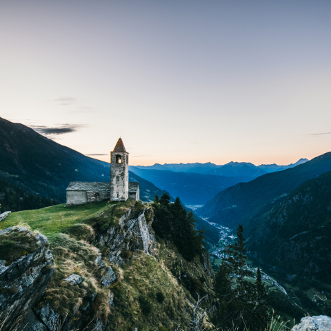 Die Kirche San Romerio thront spektakulär auf 1800 m oberhalb der Valposchiavo – ein stiller Ort mit Weitblick (Foto: © Christiane Setz-Müller & Moritz Müller) Bergkirche San Romerio oberhalb der Valposchiavo bei Sonnenaufgang