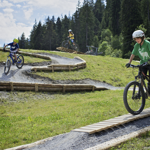 Kinder beim Mountainbiken in der Skill-Area von Flims