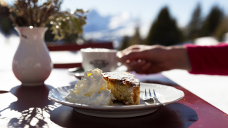 In der Skihütte Feldis füllen wir den Energiespeicher mit einem Orangenkuchen. (Foto: © Thalia Wünsche) Orangenkuchen auf der Sonnenterrasse der Skihütte Feldis