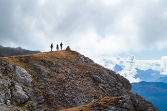 Auf einer Kuppe blickt die Trekking-Gruppe über das Bündner Gipfelmeer (Foto: © Caroline Fink) Auf einer Kuppe blickt die Trekking-Gruppe über das Bündner Gipfelmeer