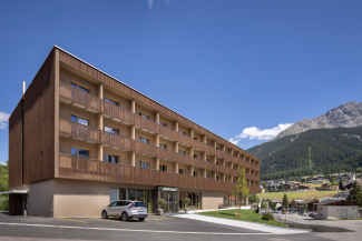 Das JUFA Hotel Savognin***s – der perfekte Rückzugsort für Familien (Foto: © JUFA Hotels / Harald Eisenberger) Aussenansicht des JUFA Hotel Savognin***s im Sommer, umgeben von grünen Wiesen und Bergen